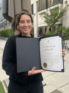 A student holds up a certificate of honor