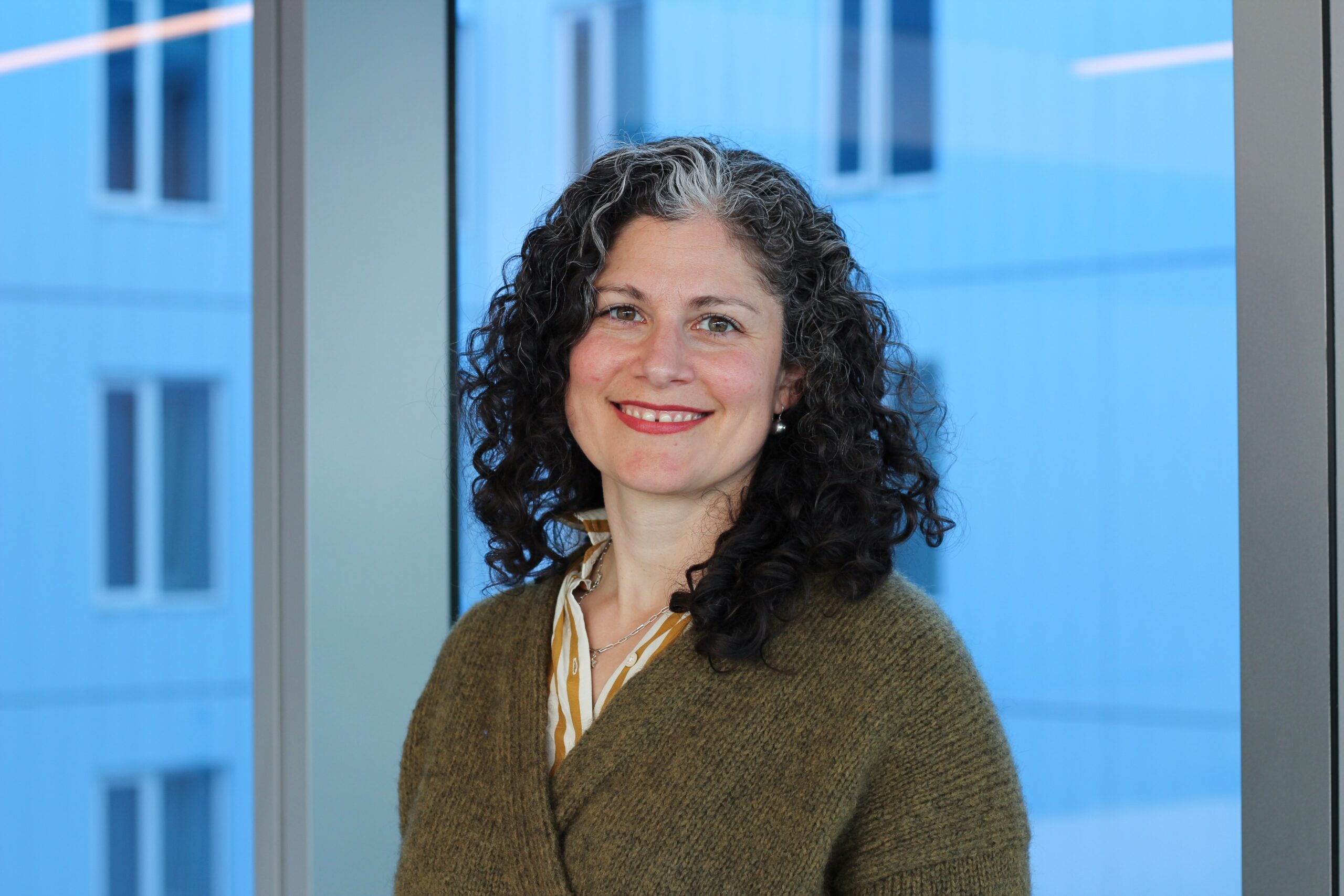 A headshot of Director of Alumni Engagement Anya Grossmann wearing a sweater in front of a window.