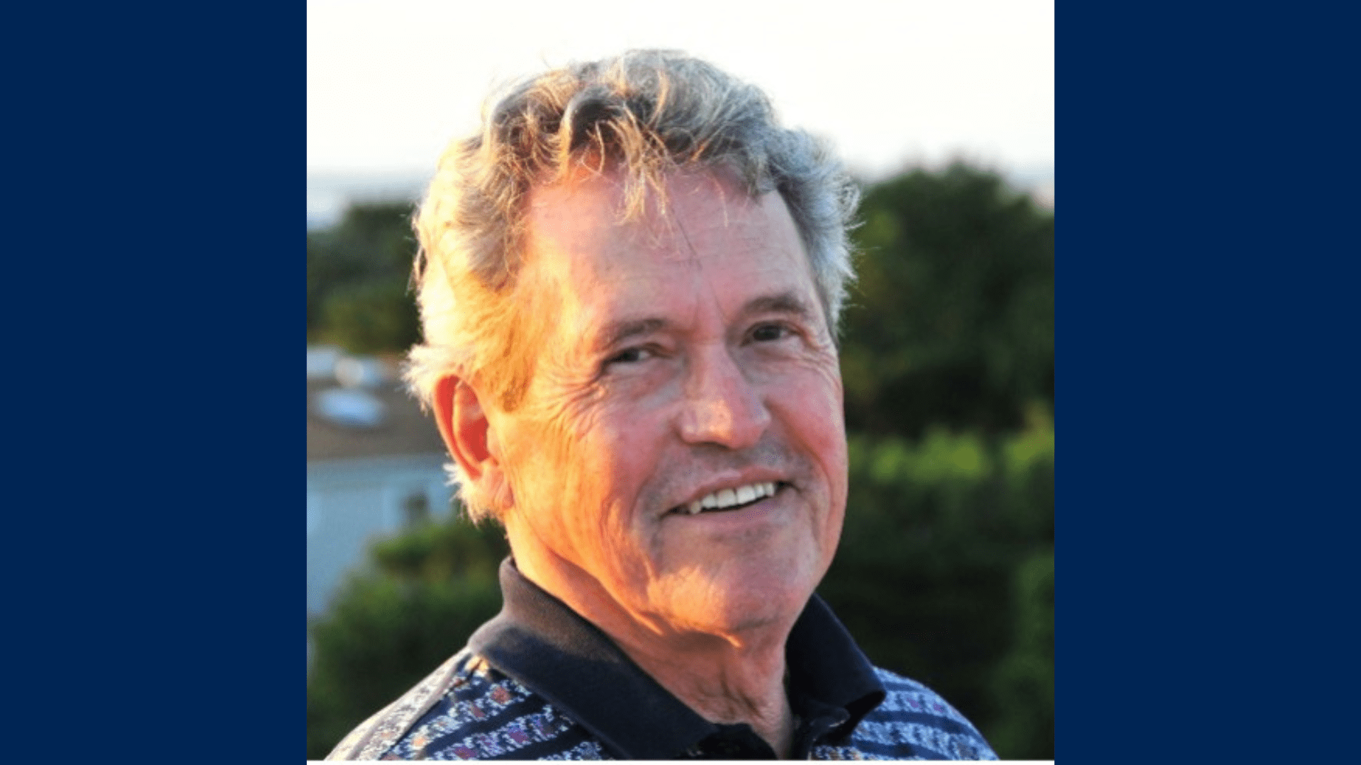A headshot phot of William Hutton in an outdoor setting