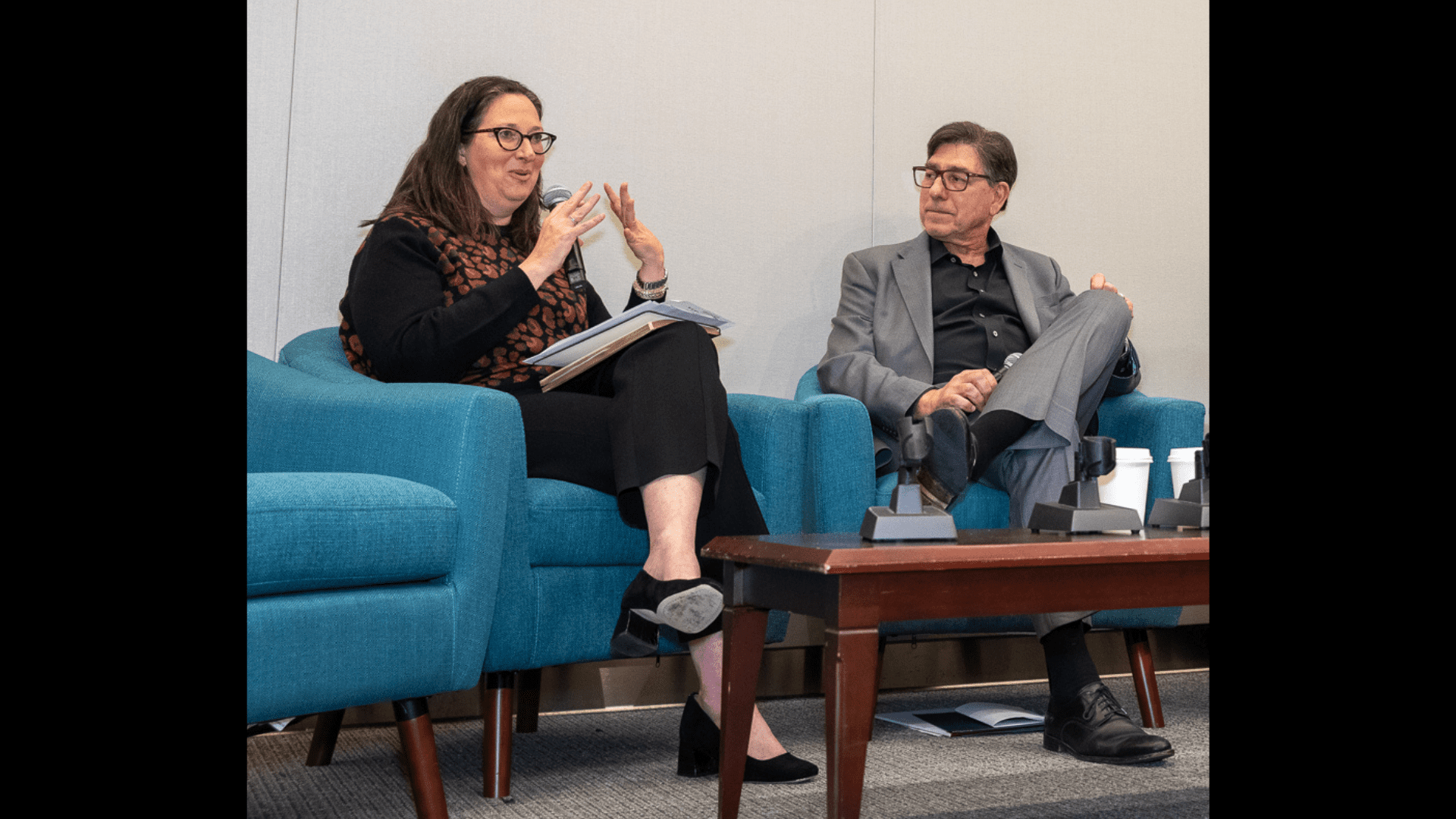 Nicole Ozer and David Faigman sit in blue chairs while having a discussion.