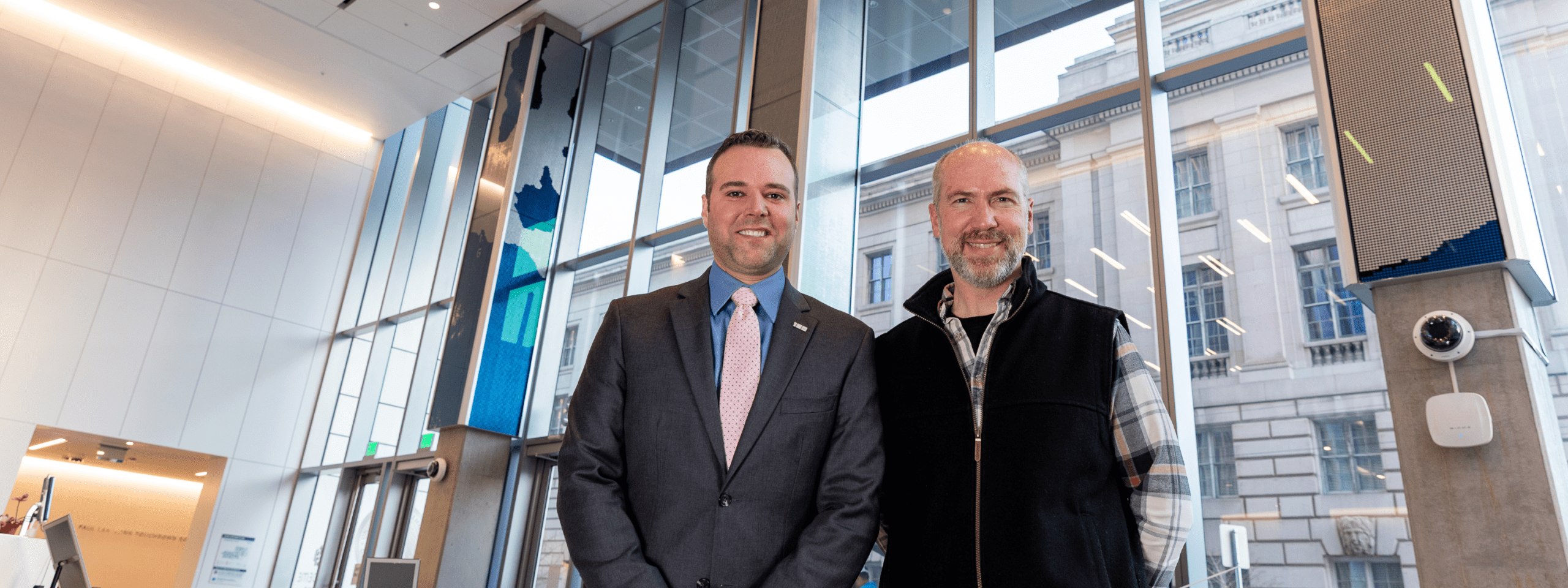 Artist Dan Goods and Christopher Gabriel of Stratin Engineering led the concept and execution of creating a massive art installation that turns live court data into visually stunning wave patterns. They are standing in front of the art installation in the 198 McAllister lobby.