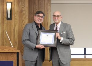 David Faigman and Matt Coles pose together, each holding the framed award certificate honoring Coles.