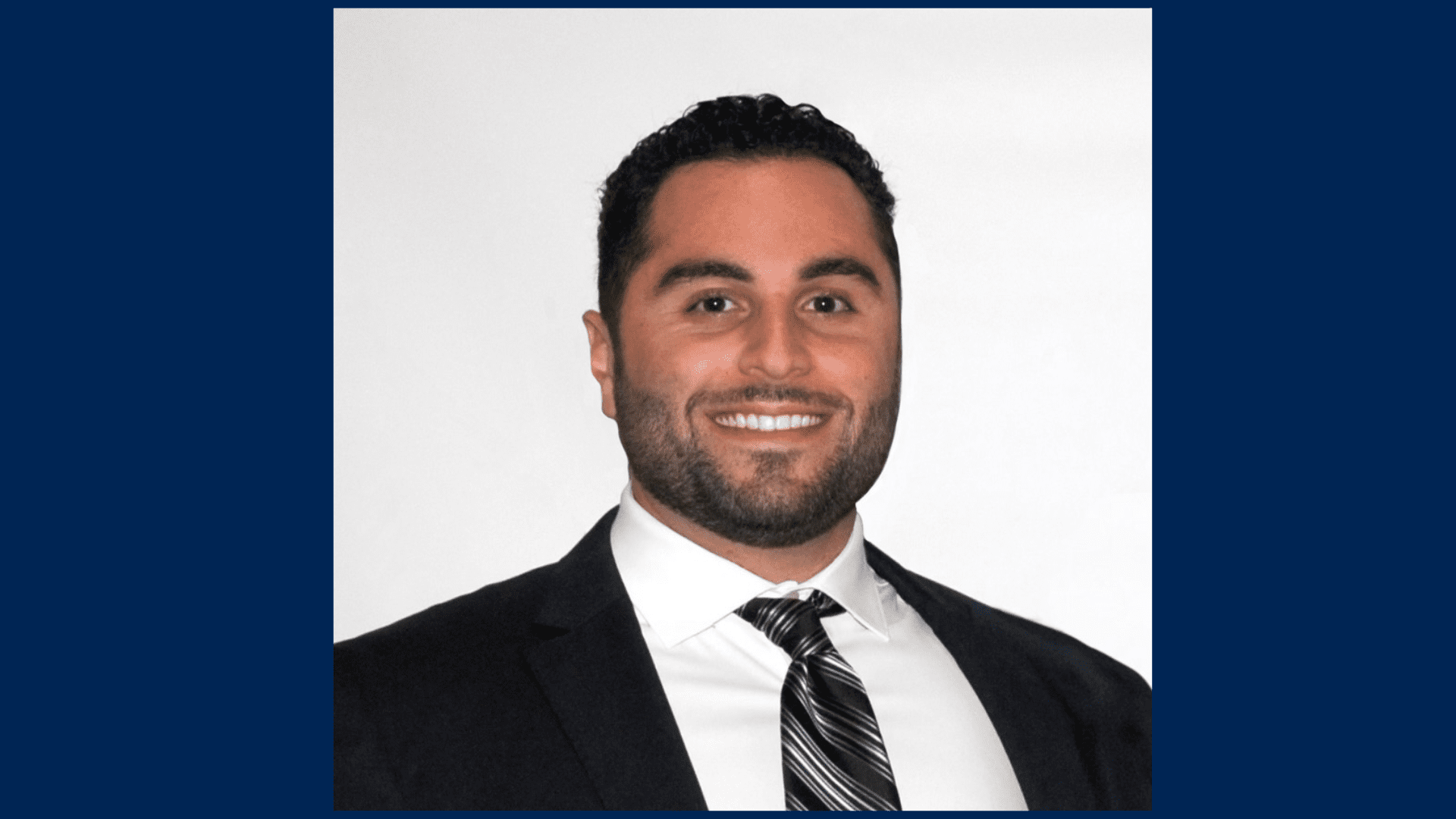 Headshot of 3L Kevin Afiesh in front of a white wall wearing a suit and tie.