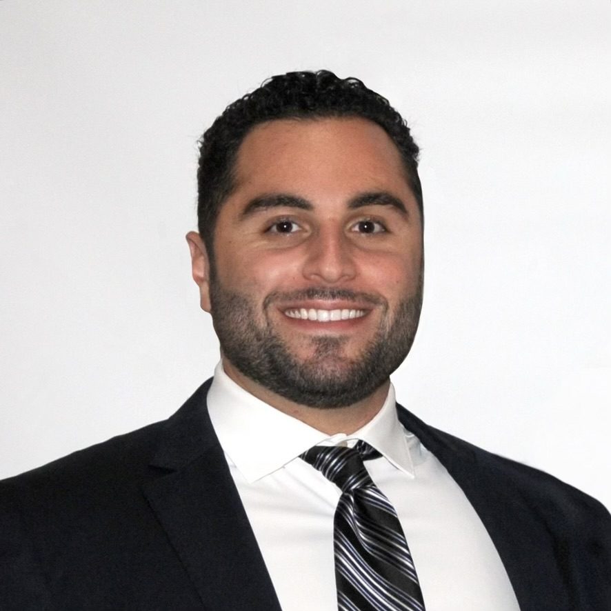 Headshot of 3L Kevin Afiesh in front of a white wall wearing a suit and tie.
