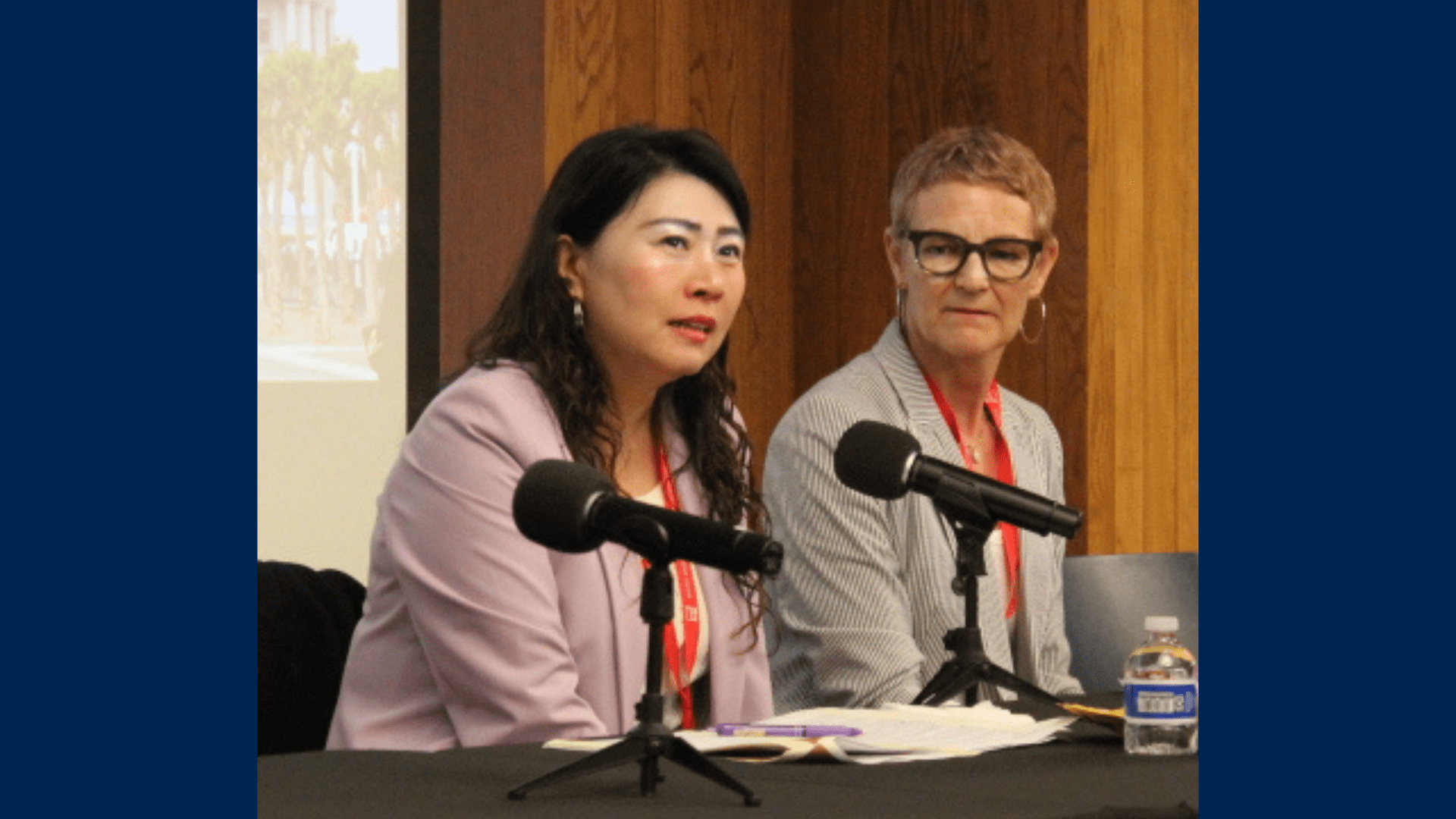 MLS alums Lucy Dong (left) and Rosalie Lack (center) sit a table with microphones in front of them.