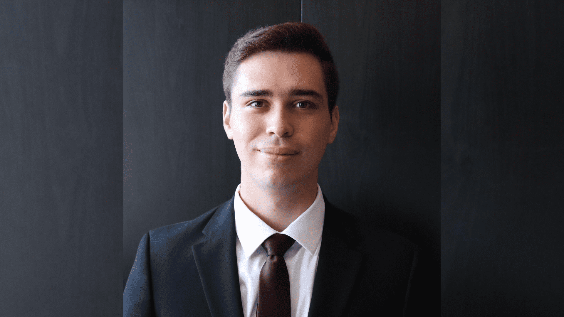 3L student William Kunkle wearing a suit and tie in front a dark background.