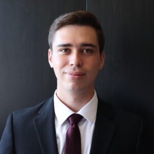 3L student William Kunkle wearing a suit and tie in front a dark background.