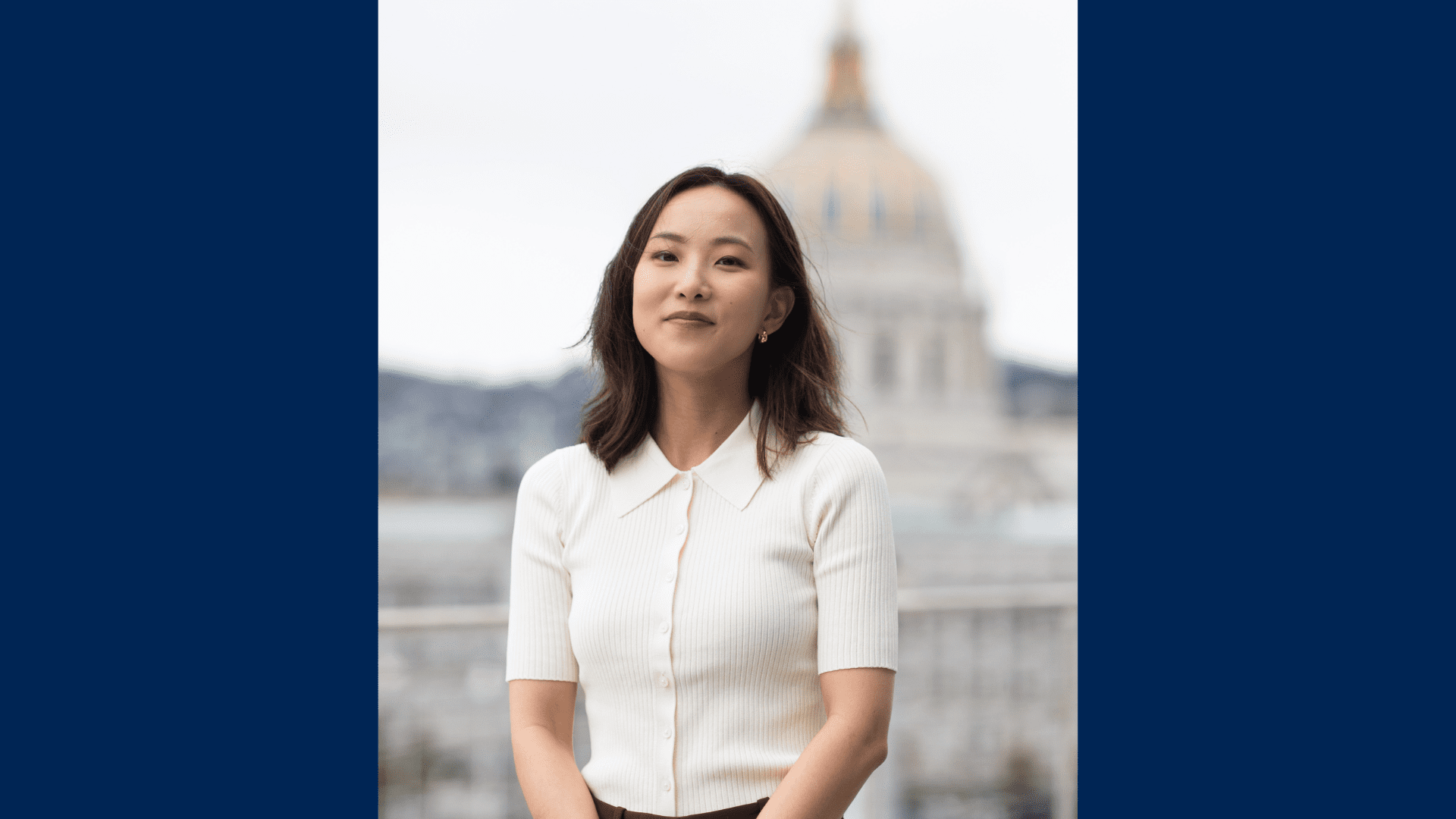 Headshot of law student Yingting Xu wearing a white shirt with the San Francisco City Hall building blurred.
