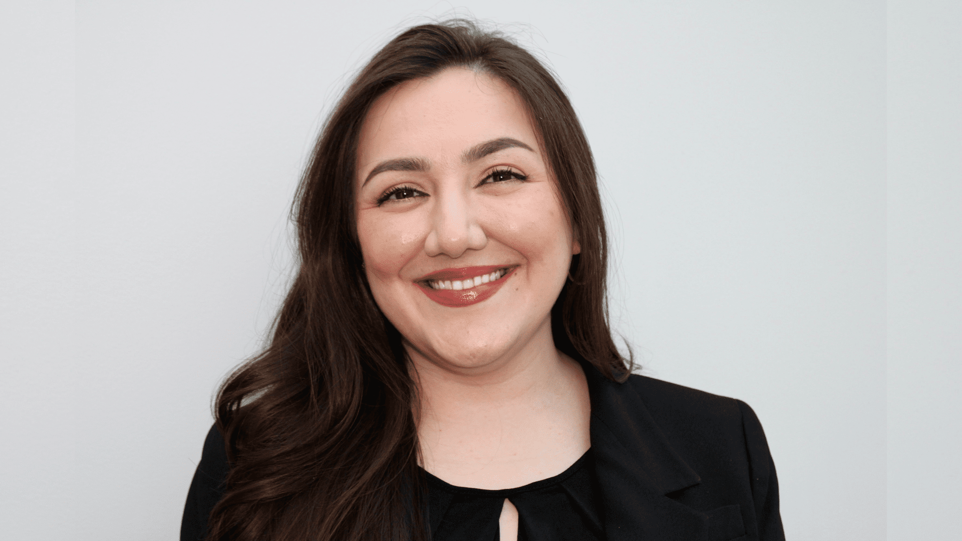 This photo is a headshot of 3L Saamia Aziz wearing a black shirt and smiling against a gray background.