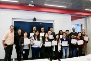 Fifteen students pose with two professors while holding their AI-Enabled Lawyering Bootcamp certificates of completion.