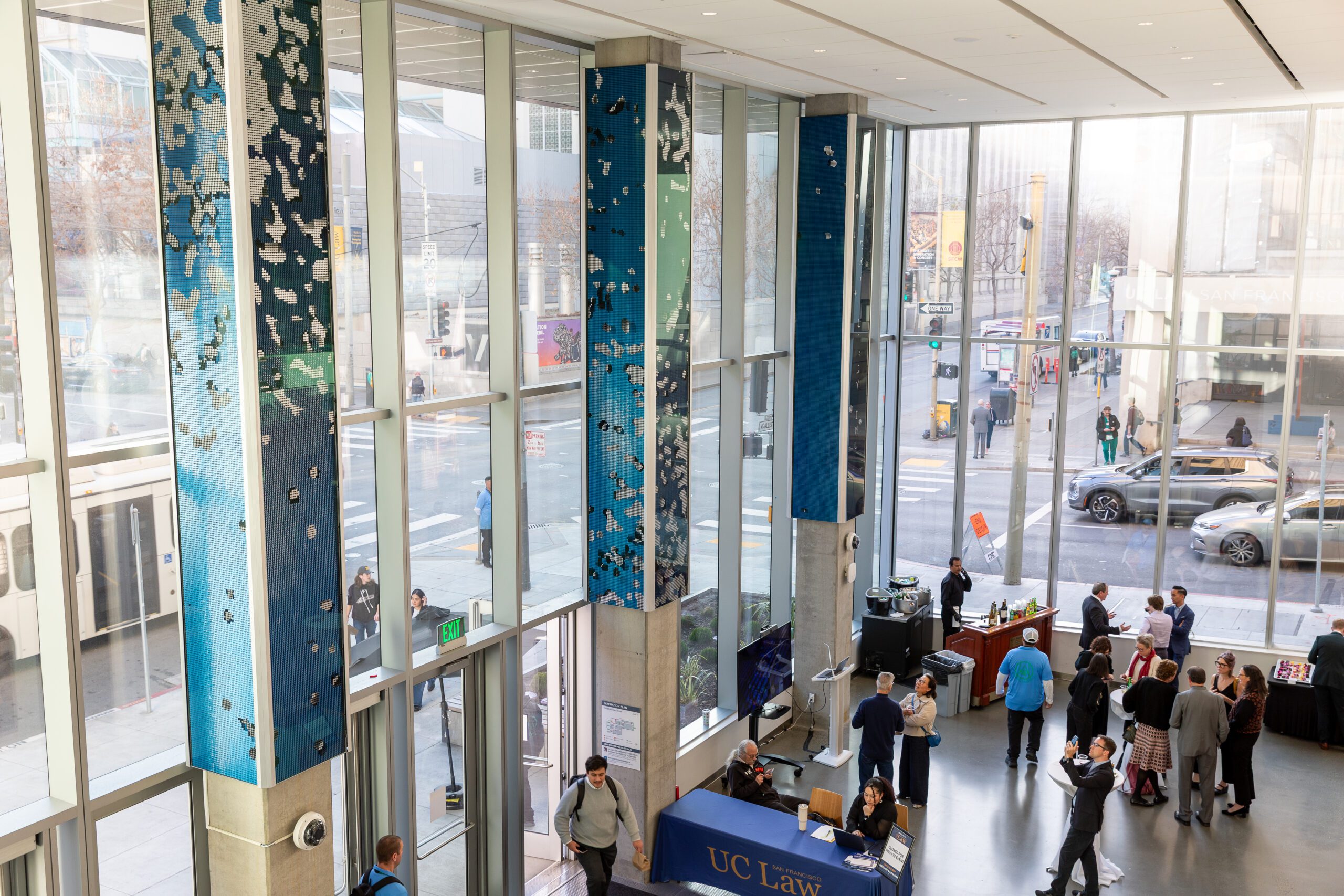 The 198 McAllister lobby filled with people. The large windows show views out onto the street
