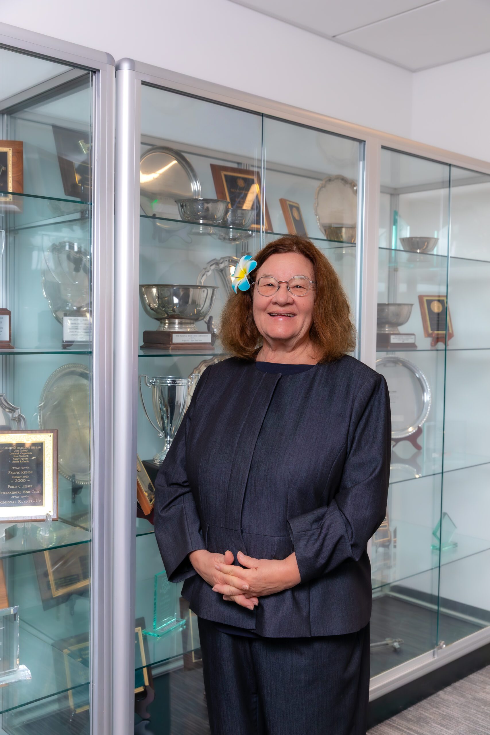 Toni Young standing in front of a trophy case