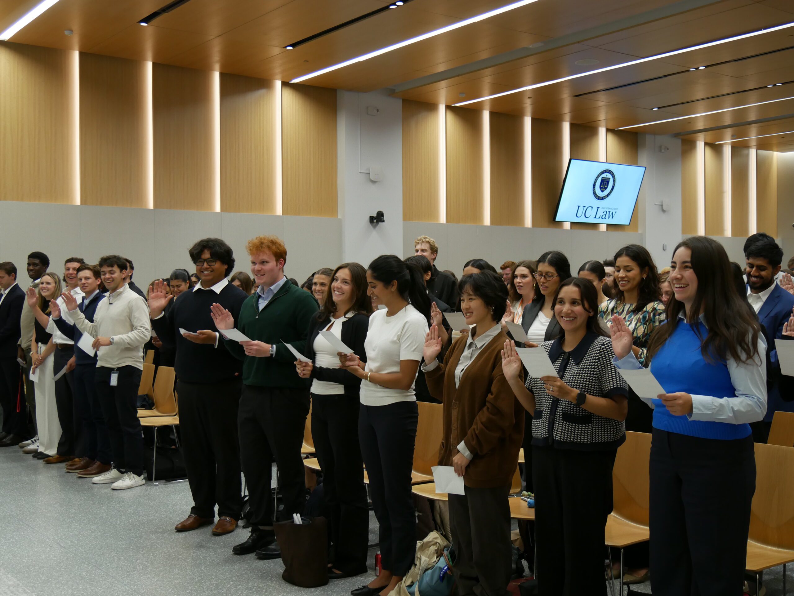 The 198 McAllister auditorium filled with 1Ls holding up their right hand and reading off their professional oath card
