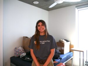 A student poses inside of an apartment unit.