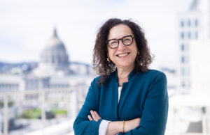 Professor Gail Silverstein poses with San Francisco City Hall in the background.