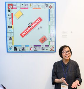 Janet Yo speaks while standing next to her artwork.