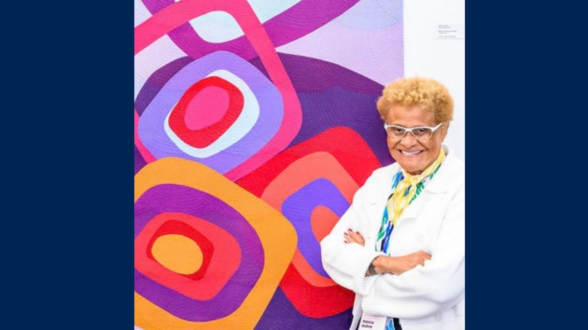 An artist poses next to her artwork.