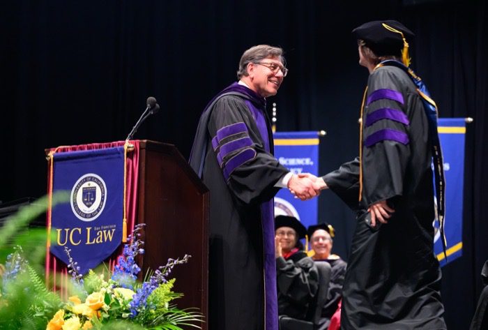A graduate shaking hands at commencement