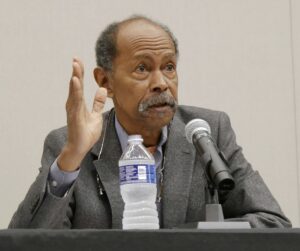 Richard Boswell speaks into a microphone.