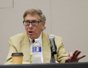 Professor Rory Little speaks into a microphone.